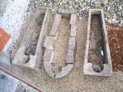 Group of limestone and chalk coffins. - The center one is composed of chalk blocks.