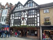 16th Century Nos. 101 and 102. God Begot House. 4 storeys. Sides and north front in fairly original condition with plaster infilling to timber framework. Front to High Street restored. Timber-framed for one half of total front, with two oversailing gables above 3-storey projecting bays. Tiled roof. Modern shop fronts and modern lattice casement windows above. East wing rebuilt 1960, but retains timbering. Building is on the site of the Manor and Sanctuary of God-be-Got, an ancient enclosure independant of the city from 952-1541. The old shambles were on the eastern side of the building. Architect B. Cancellor.    SU 480 295