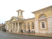 19th Century - The Public Library. Completed 1838. Street front of 1 storey. Central projecting portico, with four Tuscan stone columns on flight of stone steps. Symmetrical wings and angle pavilions of yellow stock bricks on stone plinth. Moulded stone string course at springing of window arches, large rusticated stone quoins, wide flat eaves cornice. Pediment over central portico. Square bell turret above, with brick base, stone string course, corner Doric stone pilasters and wide eaves cornice. Wooden louvres each side. Slate roofs. Formerly a corn exchange. Restored over the years. Architect: Owen Brown Carter.   SU 480 297